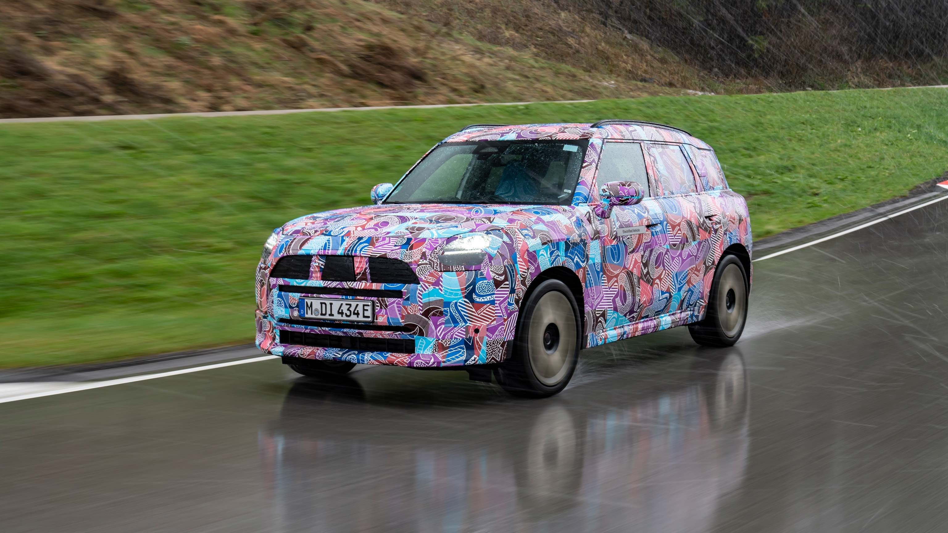 Front view of the new camouflaged MINI Countryman on the road.